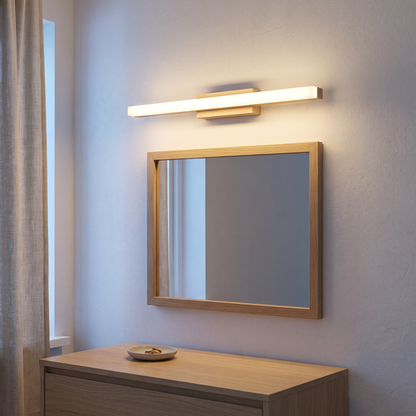 Wooden long strip LED wall sconce lit above a rectangular oak mirror over a dresser in a Nordic bedroom