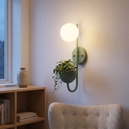 Green planter wall sconce lamp with trailing plant lit at dusk above an oak bookshelf in a living room reading corner