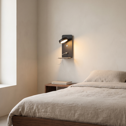 Modern square black iron LED wall sconce with shelf and USB charging port glowing warm beside a walnut bed
