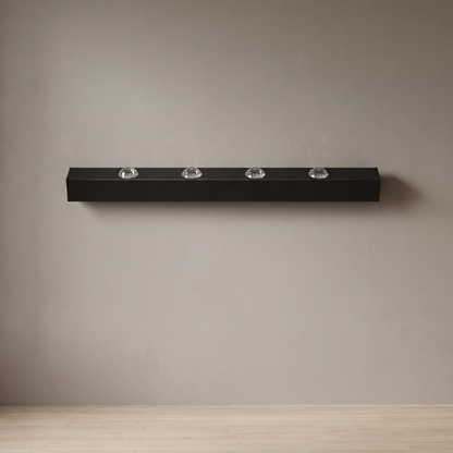 Modern LED water ripple wall wash light, 100 cm matte black aluminum bar with four crystal acrylic lenses, mounted on a plain greige plaster wall, light off