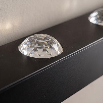 Close-up of the faceted crystal acrylic lens on the matte black aluminum LED water ripple wall wash light