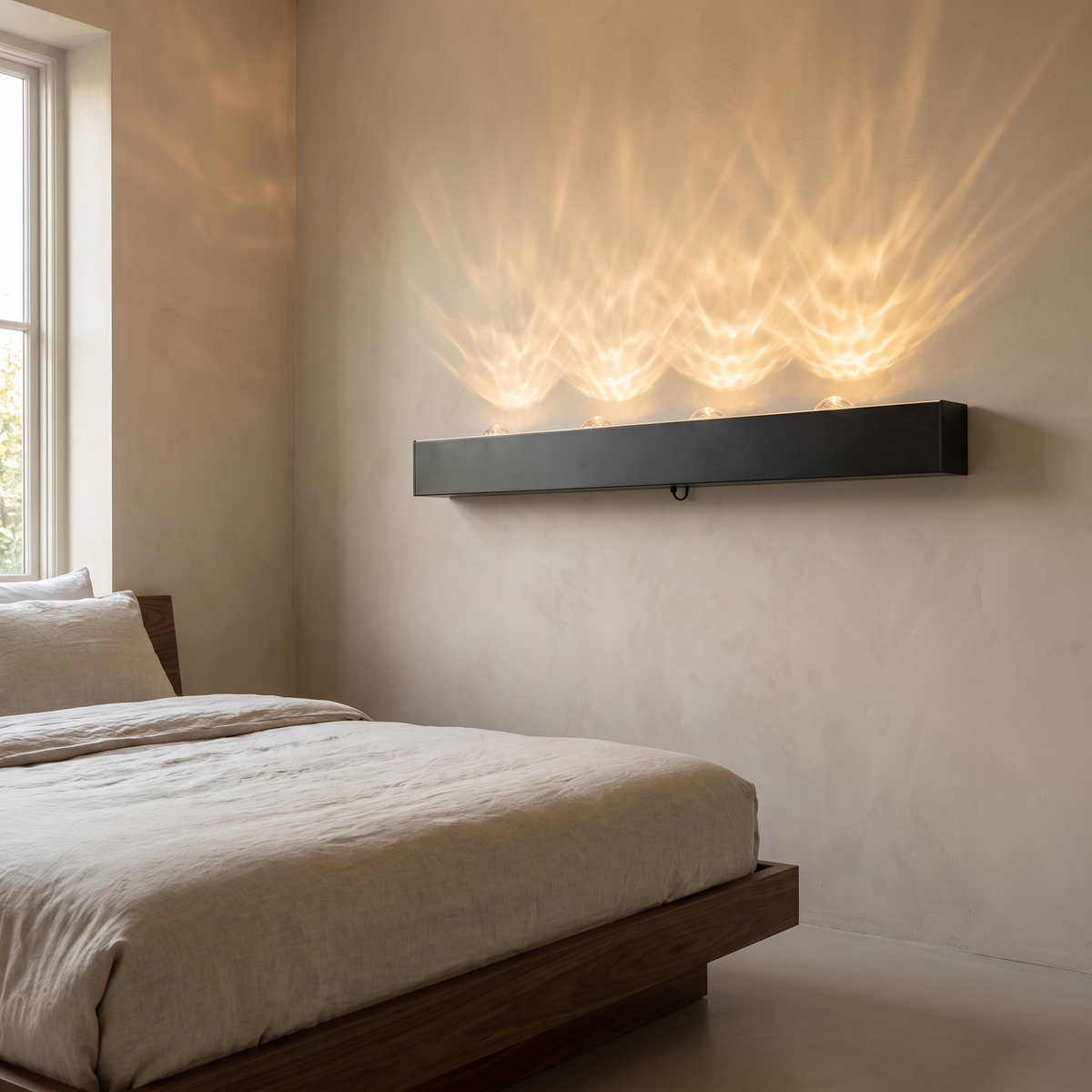 Modern LED water ripple wall wash light in matte black aluminum mounted low on a bedroom wall, glowing warm with a flowing 3D aurora ripple effect above a walnut bed