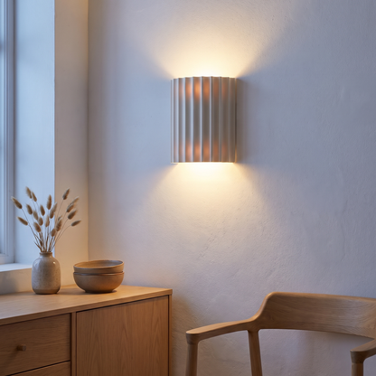 White fluted resin 2-light wall sconce lit at dusk above an oak sideboard in a Nordic dining nook, showing up-and-down glow and mounting height