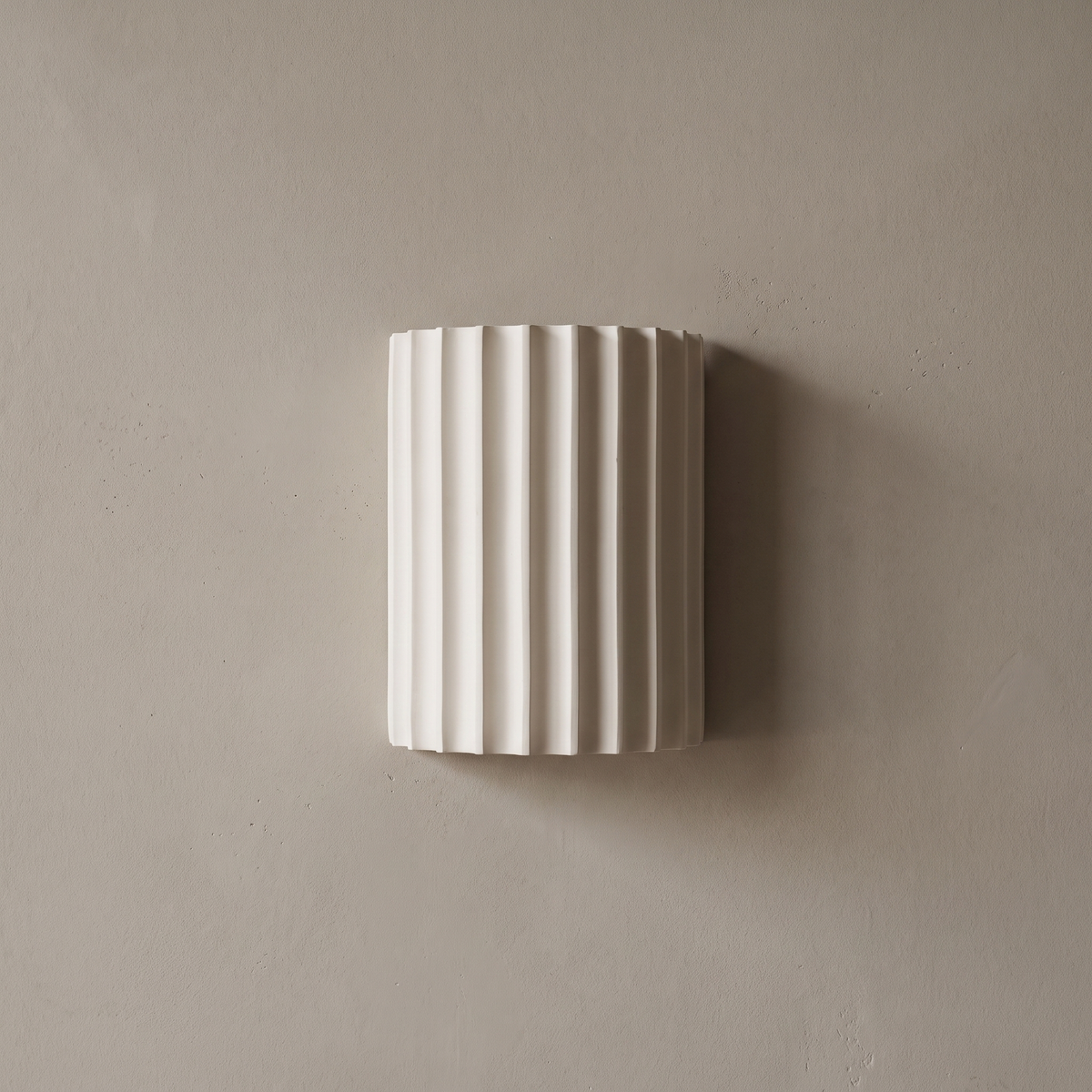 Contemporary Nordic white ribbed resin half cylinder 2-light wall sconce mounted on a plain greige plaster wall, lamp off