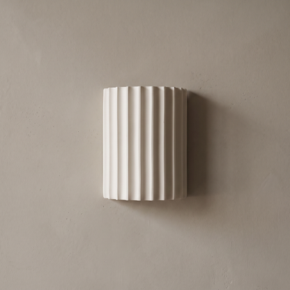 Contemporary Nordic white ribbed resin half cylinder 2-light wall sconce mounted on a plain greige plaster wall, lamp off