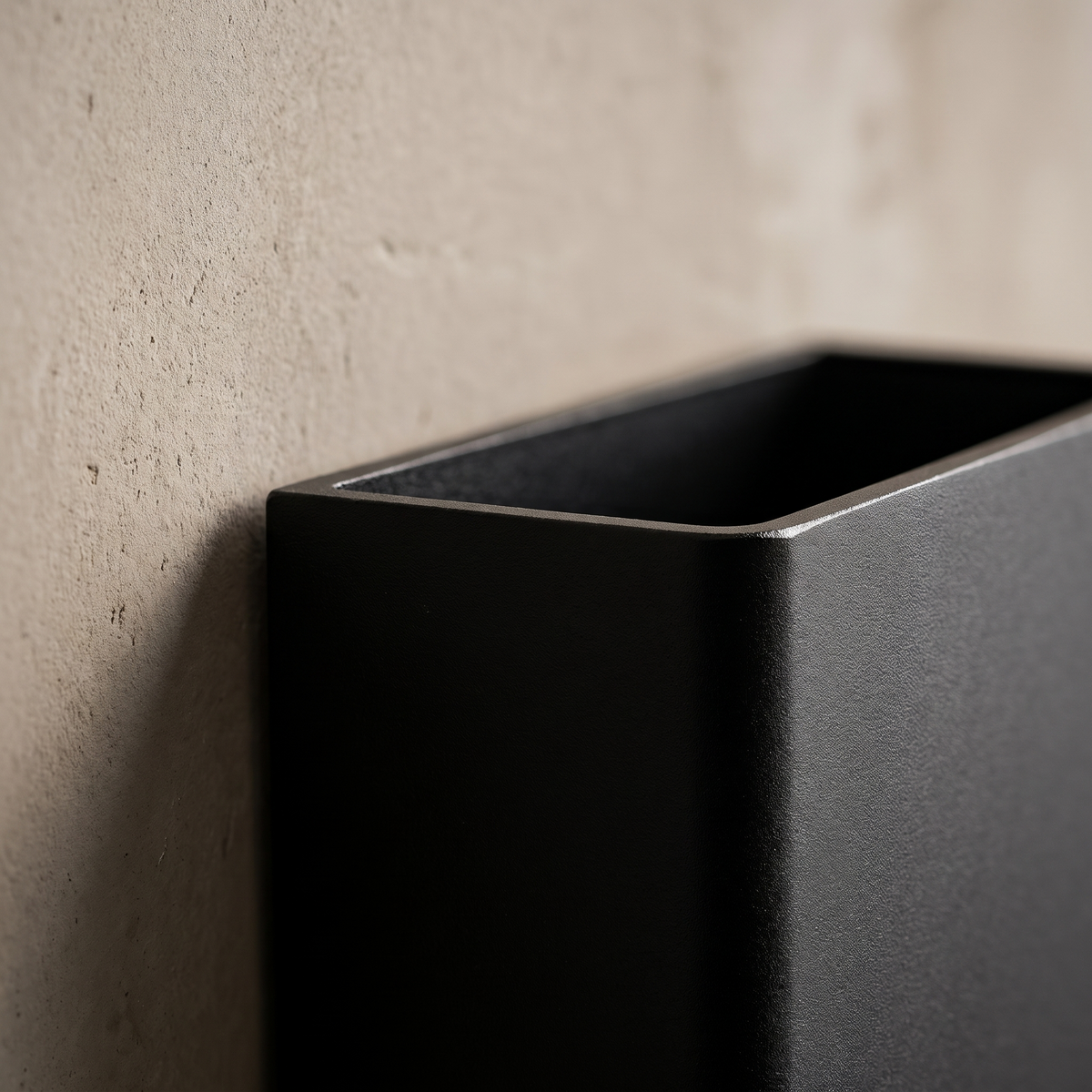 Close-up of the matte black anodized aluminum edge and top light aperture of the square LED wall sconce